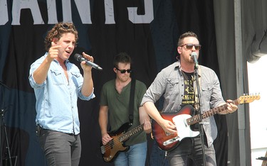 River Town Saints bass player Joe Patrois (centre), vocalist Chase Kasner (left) and guitarist Jeremy Bortot on stage in Pembroke at an outdoor concert on Saturday, Aug. 7.