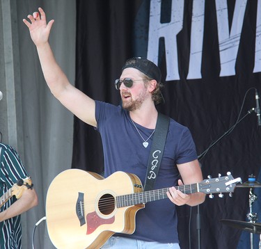 Cory Papineau, vocalist and acoustic guitar player for Lemon Cash, waves farewell to the crowd in Pembroke at an outdoor drive-in concert held on Aug. 7 at Riverside Park.