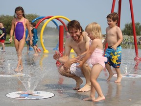 Matthieu Dallaire takes advantage of the splash pad, which recently reopened in South Porcupine after a construction, to keep himself and his kids Nicci, three, and Danik, four, cool during the heat wave that has Timmins firmly in its grips. The Environment Canada heat warning remains in effect for Timmins, Cochrane and Iroquois Falls, with no relief likely until at least Sunday.  RICHA BHOSALE/THE DAILY PRESS