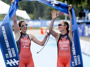 Canada's Jessica Tuomela (left) and her guide celebrate Tuomela's win at the ITU World Triathlon Edmonton, Friday July 28, 2017. Photo by David Bloom