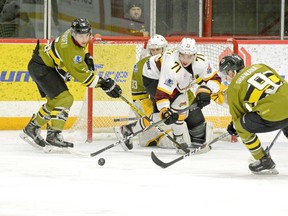 Timmins Rock forward Gabinien Kioki is surrounded by Powassan defenders Jack Craycroft, left, and Brett Shawana as he reaches for a loose puck in front of Voodoos goalie Owen Say during the first period, Feb. 6, 2020, at the McIntyre Arena. THOMAS PERRY/POSTMEDIA NETWORK