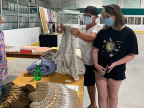 Joan and neice Aliya Eadie (R) check out hand-knit sweaters by Wilda McLelland at the Baking and Craft show at the Ripely Arena on Saturday, August 22. Hannah MacLeod/Lucknow Sentinel