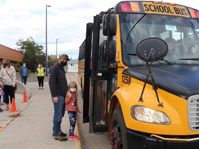 Jesse Knapp guided kindergartner Peyton to her first ride at Pat Hardy School Friday morning. Masks are still mandatory on school buses but not in the buildings. BRAD QUARIN