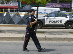 A Toronto Police officer is pictured Sunday at the scene of a quadruple shooting at Spadina Ave. and Nassau St.