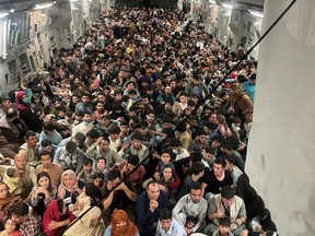 Evacuees crowd the interior of a U.S. Air Force C-17 Globemaster III transport aircraft, carrying some 640 Afghans to Qatar from Kabul, Afghanistan August 15, 2021. Picture taken August 15, 2021.