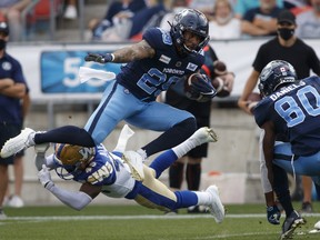 Toronto Argonauts D.J. Foster (29) avoids a tackle by Winnipeg Blue Bombers defensive back DeAundre Alford (45) during first half CFL football action in Toronto, Saturday, Aug. 21, 2021.