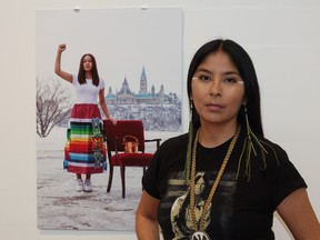 Nadya Kwandibens with one of her portraits featuring Autumn Peltier, Chief Water Protector for the Anishinabek Nation.