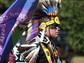 Garrett Guilbault, visiting from Sagkeeng First Nation in Treaty 1 territory, standing behind a GCT3 Pride Flag being held by Couchiching First Nation Chief Brian Perrault during the ceremonial Grand Entry.