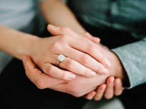 Close up of an elegant engagement diamond ring on woman finger. love and wedding concept.