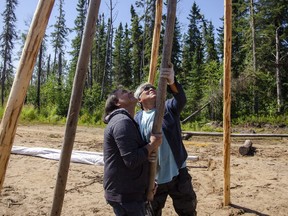 People assemble a teepee at a culture camp run by the Mark Amy Treatment Centre, located 30 kilometres east of Janvier at Cowper Lake, on August 12, 2021. Scott McLean/Fort McMurray Today/Postmedia Network