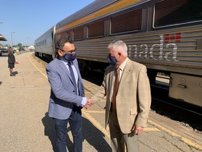 Federal transport minister Omar Alghabra, left, and Brantford Coun. John Utley posed at the Brantford VIA Rail station Thursday as the minister announced further studies into improving rail service from Toronto to Windsor.