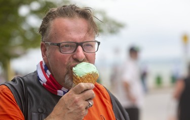 Paul Ashley of Mississauga cools down with some ice cream after driving down to take in the festivities at Port Dover's Friday the 13th biker gathering.  

(Mike Hensen/Postmedia Network)