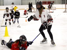 Jaden Bearspaw is pulled by midget player Morgan Boot via a stick during Girl's Hockey Day, Feb. 19, 2017.  Pat Price/Cochrane Times/Postmedia