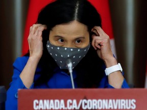 Chief Public Health Officer Dr. Theresa Tam puts on a mask at a news conference in 2020.