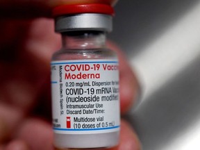 In this file photograph taken on June 29, 2021, a medical official holds a vial of the Moderna Covid-19 vaccine