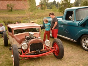 Owen and Liam Olive take a peak at a miniature hot rod during the Airdrie Summer Classic Car Show at Nose Creek Park on Saturday, Aug. 7. Photo by Riley Cassidy