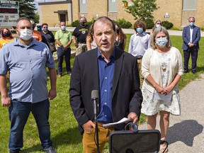 Ontario NDP leader Andrea Horwath (right) listens as Brantford-Brant NDP candidate Harvey Bischof (centre) speaks on Tuesday August 3, 2021 in front of North Park Collegiate in Brantford, Ontario.