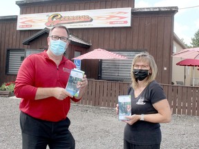 Chatham-Kent Mayor Darrin Canniff delivered copies of the new Chatham-Kent Insider brochure and map to Kim Palin, owner of The Garage Restaurant & Bar, located in Merlin on Friday. Ellwood Shreve/Postmedia Network