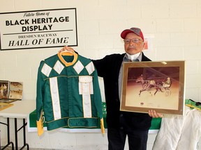 Fred List, 79, one of the Black horse drivers honoured at the Dresden Raceway on Sunday, displays the 'colours' he donated for a Black Heritage Display to be established at the track. He is also holding a photograph of the night he set the track record of 1.58:04 on July 11, 1981. Ellwood Shreve/Postmedia Network
