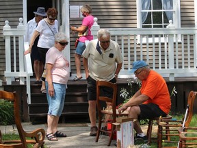 Lost Villages Historical Society president Jim Brownell drawing a gathering while doing some chair seat caning, outside Stuart House. Photo on Sunday, August 15, 2021, in Lakeview Heights, Ont. Todd Hambleton/Cornwall Standard-Freeholder/Postmedia Network