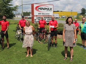 Minimax Express CEO Yves Poirier (middle, holding cheque), with cross-Canada cyclist Pierre Morin, other Minimax cyclists who joined him for the Morrisburg to Cornwall segment, and with the CMHA's Joanne Moshonas (Champlain East executive director, left) and Michelle Gosselin (Champlain East program director.Photo on Wednesday, August 18, 2021, in Cornwall, Ont. Todd Hambleton/Cornwall Standard-Freeholder/Postmedia Network