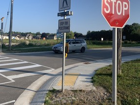 A new pedestrian activated crosswalk is fully operational at the corner of Henry Street and St. George Street as students from the west side of Mitchell walk safely back and forth to school starting next week. Crossing guards are still needed, however, both here and elsewhere as another school year begins. ANDY BADER/MITCHELL ADVOCATE