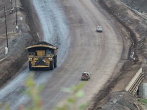 A heavy hauler drives past smaller trucks near the entrance of Suncor Energy's North Steepbank Mine, located north of Fort McMurray, Alta., in this 2014 file photo. Vincent McDermott/Fort McMurray Today/Postmedia Network  ORG XMIT: nghLN4_CiB4tozteTmZk ORG XMIT: POS1709271754233137