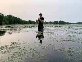 Emma Langley of Swim Drink Fish demonstrates on Tuesday how to take a water sample for testing, during a gathering of community activists and those seeking better treatment for the Cataraqui River and the Inner Harbour in Kingston.