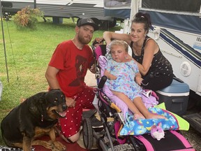 Graham and Maureen Wright, with their daughter, Faith, on Saturday, Aug. 7, outside the tent trailer they have been living out of for the past three weeks while searching for housing in the city of Kingston.