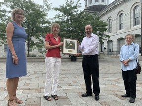 Denice Wilkins, second from left, of the Ontario Nature Board, presents Kingston Mayor Bryan Paterson and Julie Salter Keane, left, manager of the Climate Leadership Division at the City of Kingston, with the Lee Symmes Municipal Award, accompanied by Susan Irving, right, of the Kingston Field Naturalists in Springer Market Square on Wednesday.