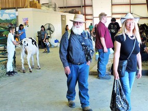 Photo by LESLIE KNIBBS/FOR THE STANDARD
Local farmer and poet Charlie Smith and his wife enjoy a walk through the livestock building at the 2019 Massey Fair.