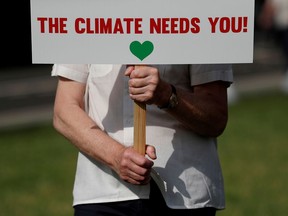 FILE PHOTO: A protester from the Climate Coalition demonstrates, with 100 hundred days to go before the start of the COP26 climate summit, in Parliament Square, London, Britain, July 23, 2021.  REUTERS/Peter Nicholls/File Photo