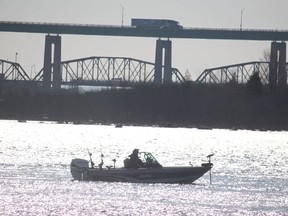 Anglers are on the St. Mary's River while a transport heads northbound on the International Bridge on Friday, April 16, 2021 in Sault Ste. Marie, Ont. (BRIAN KELLY/THE SAULT STAR/POSTMEDIA NETWORK)