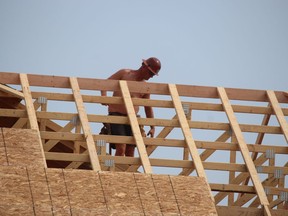 A construction worker is shown on the job at a new home under construction.