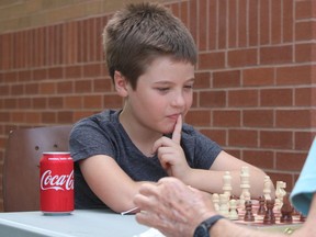 Oliver Weiler Riveiro DePaula, 10, takes part in Chess in the Park Friday at the Strangway Centre in Sarnia. It's a weekly intergenerational program offered during August by the centre, Lambton Elderly Outreach's Peer Program and LEADS Employment.