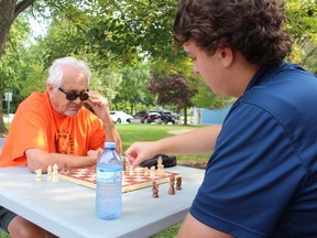 Benton DeGurse, 17, right, and Ron Wallace take part in Chess in the Park Friday at the Strangway Centre in Sarnia. It's a weekly intergenerational program offered during August by the centre, Lambton Elderly Outreach's Peer Program and LEADS Employment.