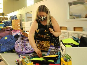 Adrienne McPhee, program manager at the Inn of the Good Shepherd, packs one of the 1,000 back-to-school kits the Inn is assembling this year for local families in need. It's one of the services provided by the Sarnia agency and supported by donations and fundraisers, including its Local Shopping Spree Raffle.