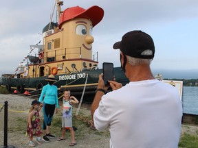Doug Kennedy of Corunna takes a photo of his wife, Charlotte Kennedy, and their grandchildren, Vivien Drew, 2, and Charlie Drew, 7, Thursday next to Theodore TOO at the Mooretown Dock. It was the first of several stops the replica of the title character of the former children's TV show, Theodore Tugboat, is making in the Lambton County in the coming days.