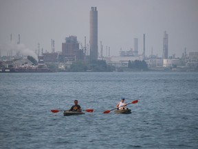 Sarnia's Chemical Valley can be seen in the background as kayakers paddle Saturday in the St. Clair River.