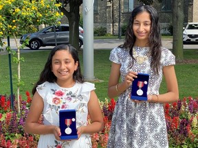Diya Duggal, 11, left, and Raveena Duggal, 14, hold the Sovereign's Medals for Volunteers the Sarnia sisters received from the office of the governor general.