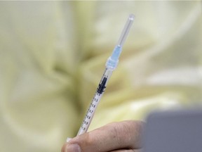 A health care worker prepares a Covid-19 vaccination. PHOTO BY ALLEN MCINNIS /Montreal Gazette