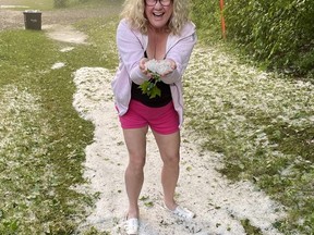Diane Taylor, who is spending the summer in Port Dover, poses with a handful of hail that fell in the area on Sunday. The photo was taken on the Radical Road between Port Dover and Turkey Point. CONTRIBUTED