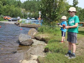 Roger Lamontagne, 7, back, and his brother, Rheal, 9, try their luck at fishing at Camp Bitobig at Lake Laurentian in Sudbury, Ont. on Monday August 9, 2021. John Lappa/Sudbury Star/Postmedia Network