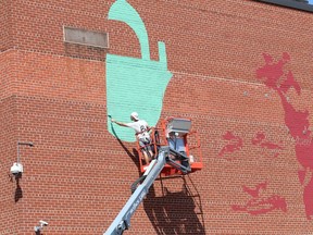 Kevin Ledo works on his mural at Sudbury Secondary School in Sudbury, Ont. for the Up Here urban art and music festival on Thursday August 12, 2021. Ledo said it should take seven to ten days to complete. John Lappa/Sudbury Star/Postmedia Network
