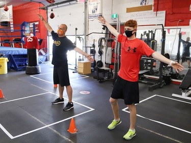 Sudbury MPP Jamie West, left, and Owen Paquette, 16, a Quest for Gold athlete, stretch prior to competing in a series of physical challenges geared to boxing at Top Glove Boxing Academy in Sudbury, Ont. on Friday August 13, 2021. The Quest for Gold program is designed for athletes to achieve their goals. Paquette's goal is to represent Canada in the 2024 Olympic games. John Lappa/Sudbury Star/Postmedia Network