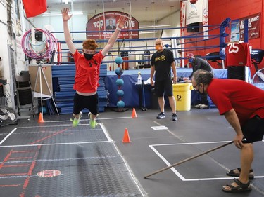 Owen Paquette, 16, a Quest for Gold athlete, takes part in a challenge as Sudbury MPP Jamie West, middle, and Gord Apolloni, of Top Glove Boxing Academy, look on during a series of physical challenges geared to boxing at Top Glove Boxing Academy in Sudbury, Ont. on Friday August 13, 2021. The Quest for Gold program is designed for athletes to achieve their goals. Paquette's goal is to represent Canada in the 2024 Olympic games. West and Paquette competed in a series of challenges. John Lappa/Sudbury Star/Postmedia Network