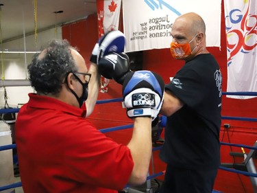 Gord Apolloni, left, of Top Glove Boxing Academy,  instructs Sudbury MPP Jamie West in one of a series of physical challenges against Owen Paquette, 16, a Quest for Gold athlete, at Top Glove Boxing Academy in Sudbury, Ont. on Friday August 13, 2021. The Quest for Gold program is designed for athletes to achieve their goals. Paquette's goal is to represent Canada in the 2024 Olympic games. John Lappa/Sudbury Star/Postmedia Network