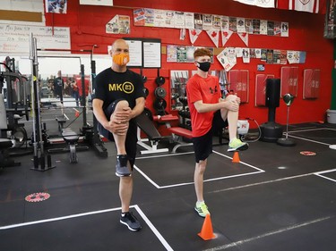 Sudbury MPP Jamie West, left, and Owen Paquette, 16, a Quest for Gold athlete, stretch prior to competing in a series of physical challenges geared to boxing at Top Glove Boxing Academy in Sudbury, Ont. on Friday August 13, 2021. The Quest for Gold program is designed for athletes to achieve their goals. Paquette's goal is to represent Canada in the 2024 Olympic games. John Lappa/Sudbury Star/Postmedia Network