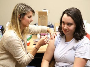 Public health nurse Landa Koski, left, gives Danika St-Jacques, 15, a shot at a free vaccination clinic at the Public Health Sudbury and Districts location off of Paris Street.