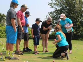 Kaylen Burgess, third from right, executive director of Big Brothers Big Sisters of Sarnia-Lambton, livestreams the judging of the results of the $2,500 Big Drop fundraiser held at the Greystone Golf Course on Aug. 4. The winning ball was the closest to the hole when more than 1,500 were dropped from a crane. Paul Morden/Postmedia Network